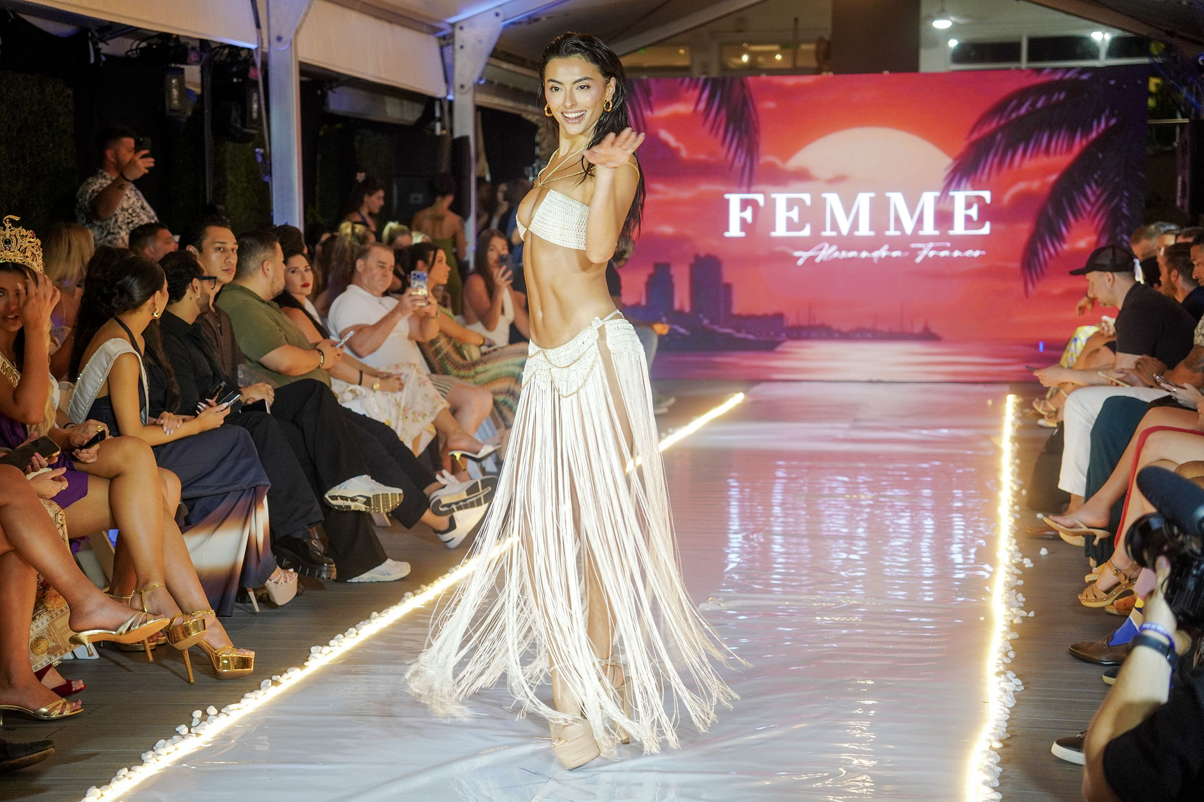 Model in a white fringed runway look waves during The Deity Show at Miami Swim Week 2026.